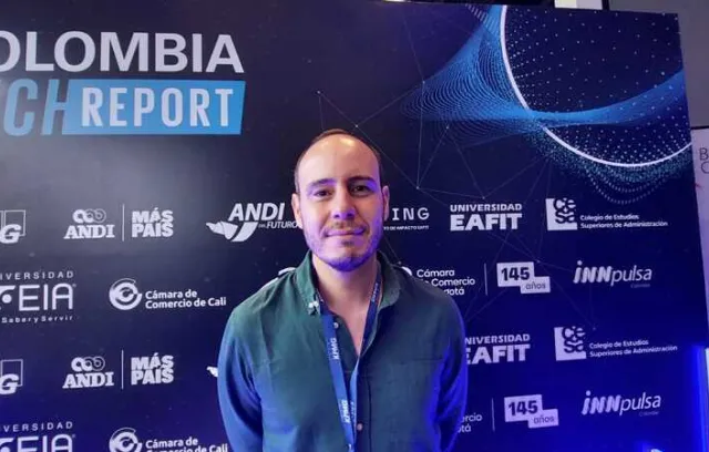 Foto de un hombre joven mirando a la camara con un fondo de kpmg