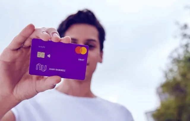 Foto de un hombre sosteniendo una tarjeta morada en sus manos