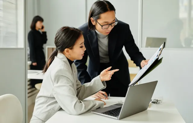 Foto de un hombre y una mujer trabajando frente a un computador