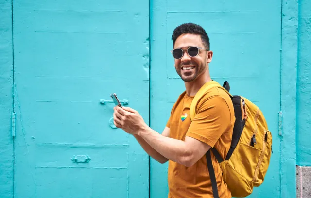 Foto de un joven sonriendo a la camara con camiseta amarilla