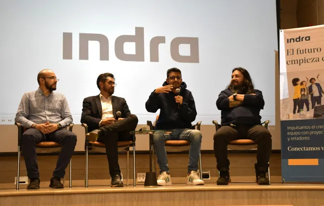 Foto de un panel con cuatro personas sentadas