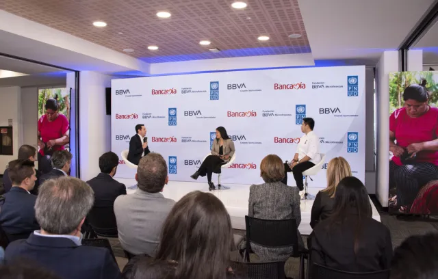 Foto de un panel con tres personas sentadas conversando Bancamía