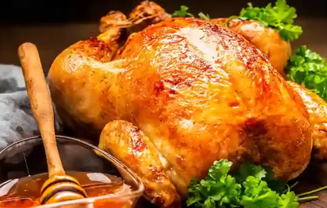 Foto de un pollo junto a un frasco de miel al costado