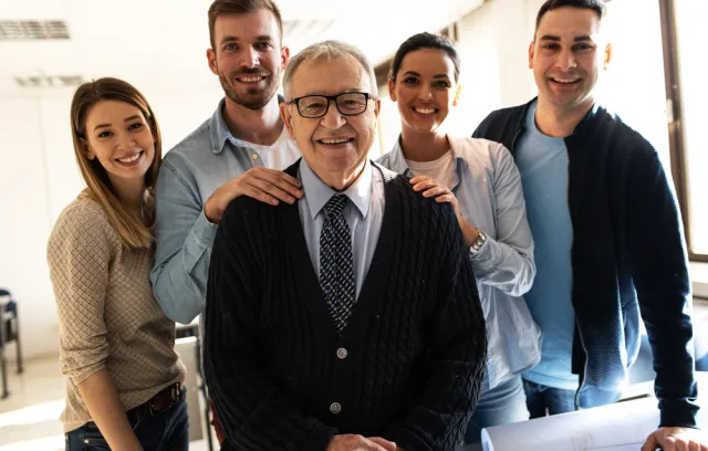 Foto de un señor con varias personas de fondo