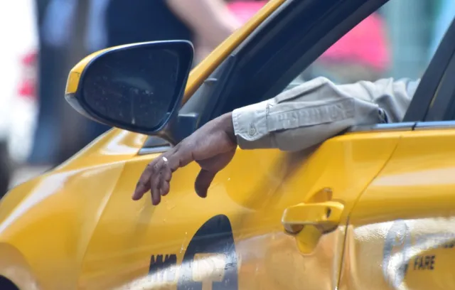 Foto de un taxista con la mano por fuera