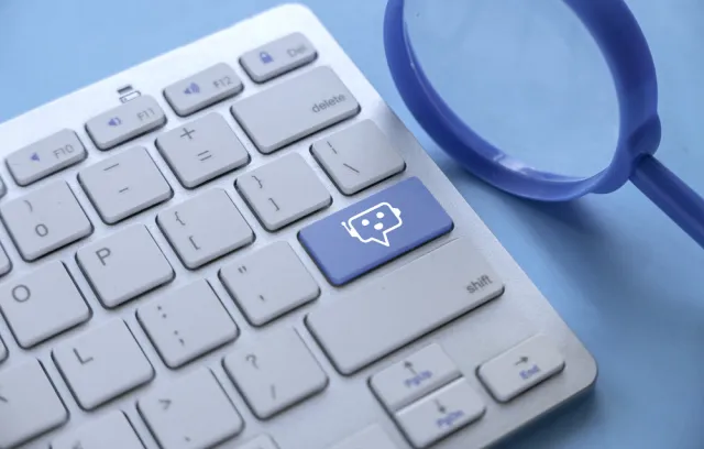 Foto de un teclado blanco con una tecla azul que simula un pc