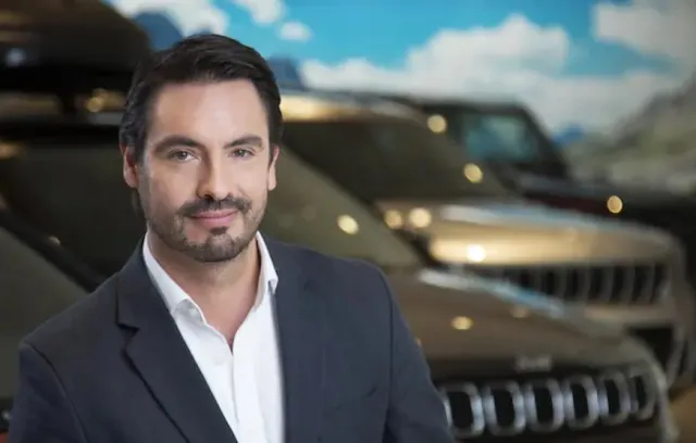 foto de un ejecutivo con una camioneta de fondo