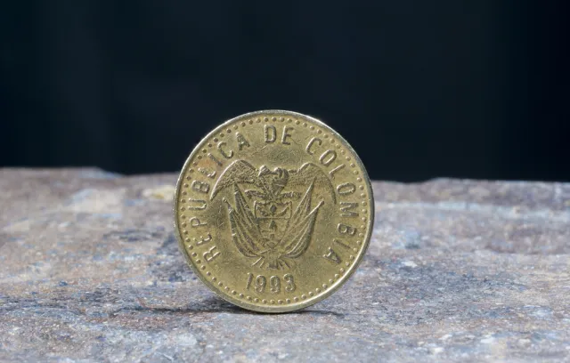 Foto de una imagen de 100 pesos de un lado con un fondo negro