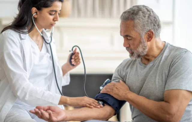 Foto de una médica tomándole el puso a un hombre