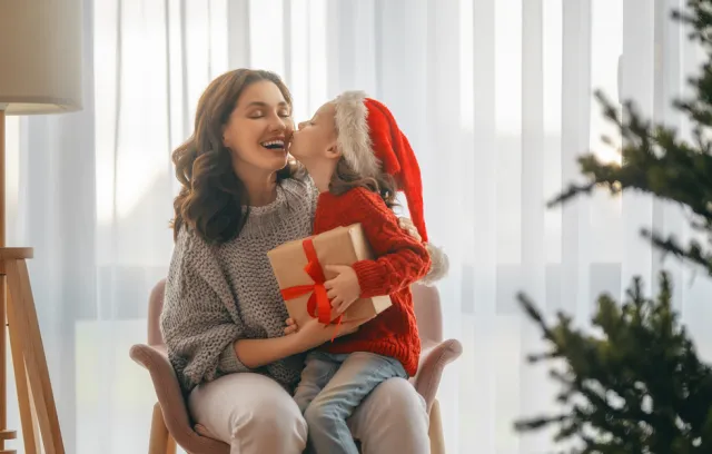 Foto de una mandre y su hija sentadas con detalles de navidad