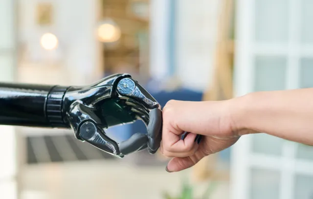 Foto de una mano natural y de un robot chocando