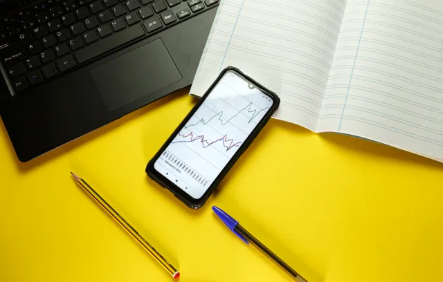 Foto de una mesa con un celular con una gráfica en su pantalla