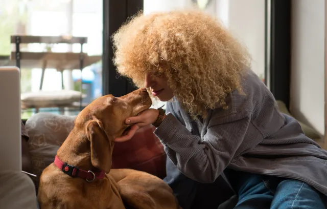 Foto de una mujer acariciando un perro