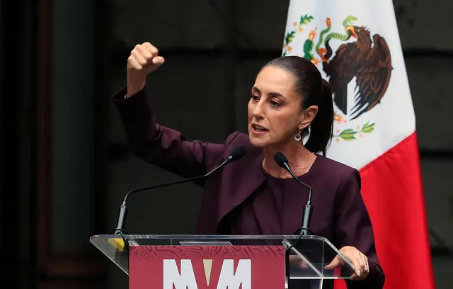 Foto de una mujer con el puño arriba y detrás de ella una bandera de méxico