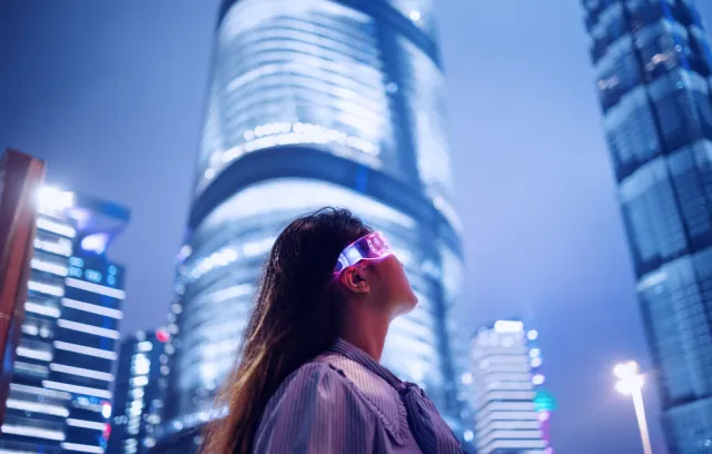 Foto de una mujer con gafas tecnológicas y un fondo de ciudad