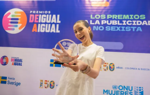 Foto de una mujer con un premio en sus manos 