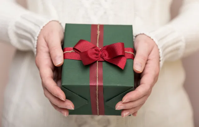 Foto de una mujer con un regalo en sus manos