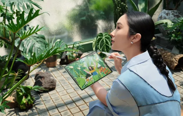 Foto de una mujer con una tablet en la mano y un paisaje de fondo