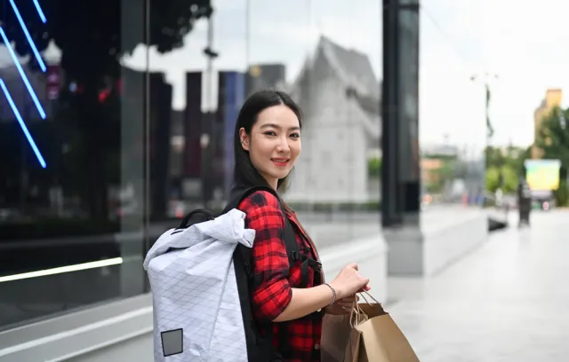 Foto de una mujer con unas bolsas en la calle