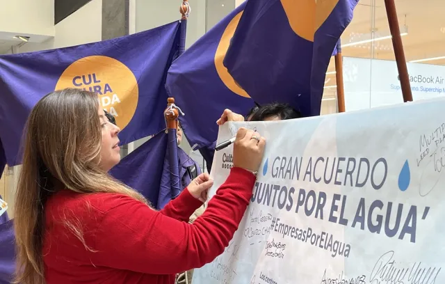 Foto de una mujer firmando un acuerdo con la mano