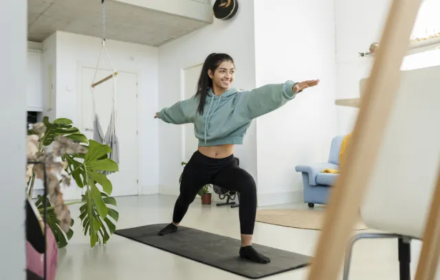 Foto de una mujer haciendo yoga encima de una colchoneta