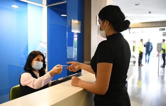 Foto de una mujer pagando un servicio en una eps