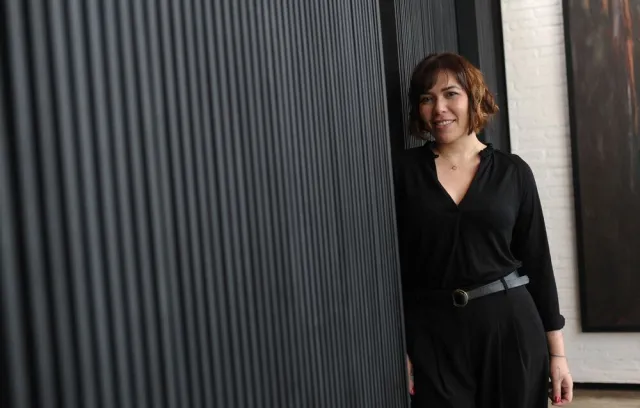 Foto de una mujer posando sobre una pared