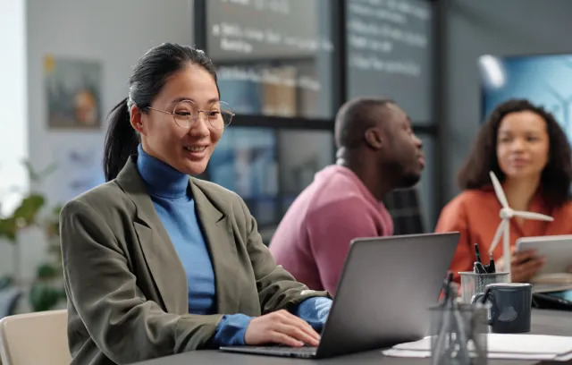 Foto de una mujer sonriendo frente a un computador