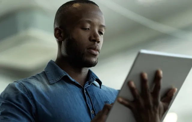 Foto de una persona afro con una tablet en la mano