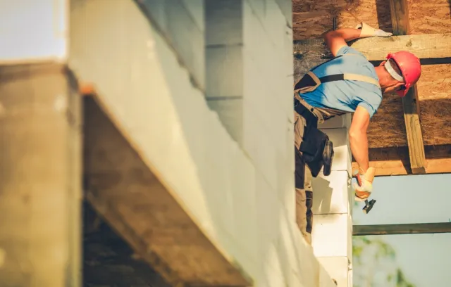 Foto de una persona con un casco en una construcción