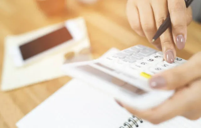 Foto de una persona con una calculadora en la mano