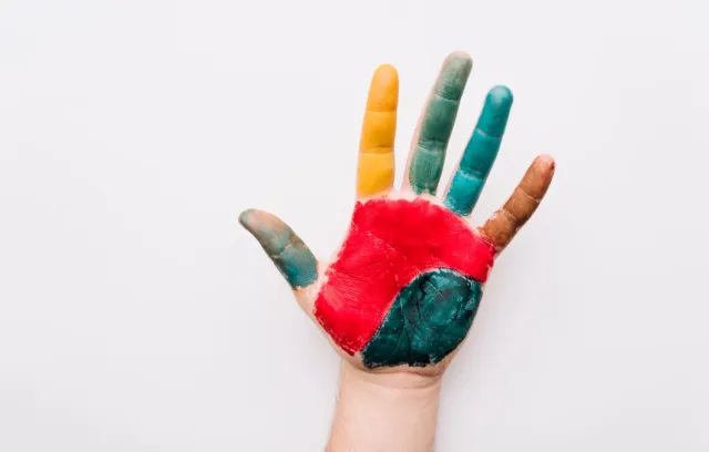 Foto de una persona con una mano pintadas de varios colores