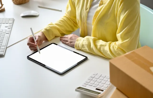 Foto de una persona con una tablet en la mesa