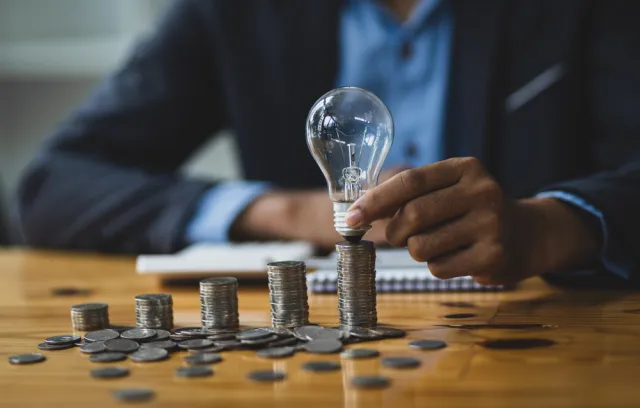Foto de una persona con unas monedas sobre la mesa