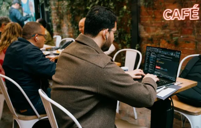 Foto de una persona de espaldas escribiendo sobre un computador