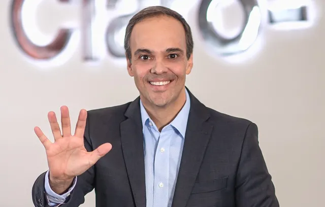 Foto de una persona saludando a la cámara anunciando el número 5