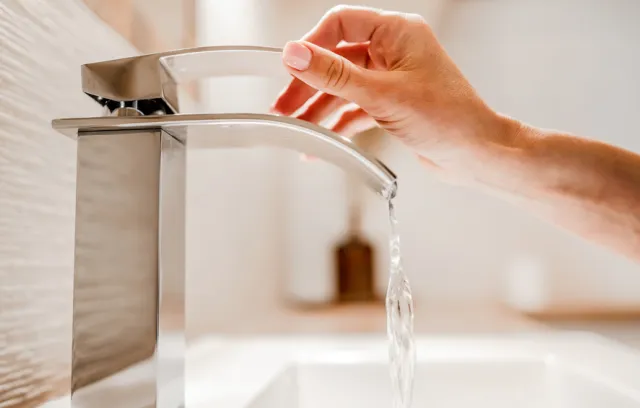 Foto de una persona utilizando un grifo de agua
