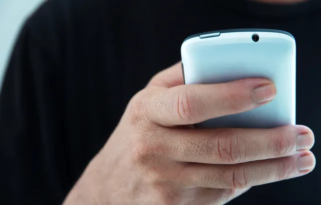 Foto de una persona utilizando un teléfono de color azul aguamarina