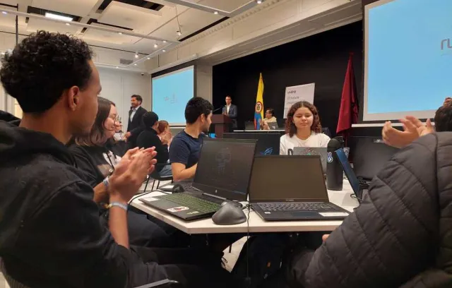 Foto de varias jóvenes sentados en una mesa mirando el computador