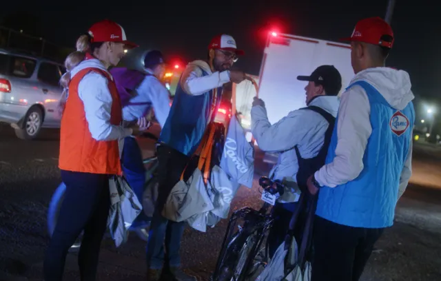 Foto de varias personas entregando kits en la calle