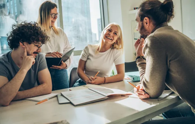 Foto de varias personas hablando sobre una mesa