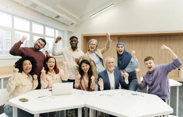 Foto de varias personas levantando la mano y sonriendo a la cámara