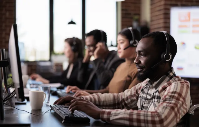 Foto de varias personas trabajando en una emrpesa frente al computador