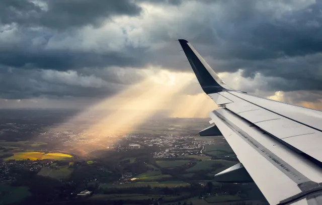 Foto del ala de un avión con un fondo terrestre