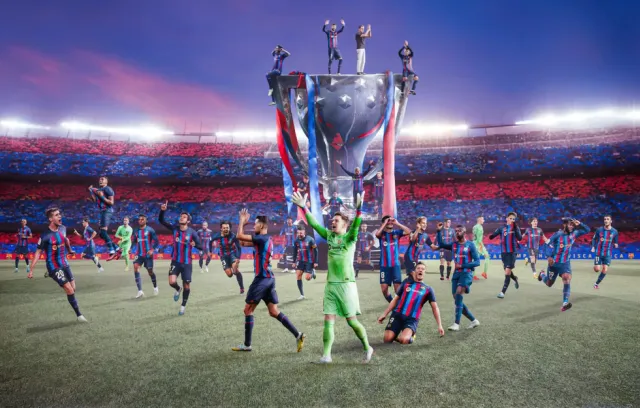 Foto del barcelona celebrando con una copa gigante de fondo