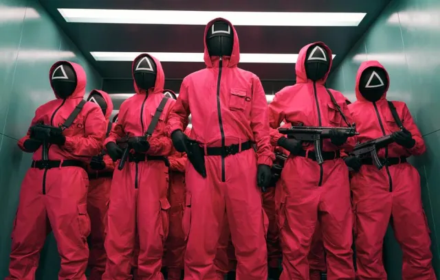 foto de varias personas con trajes y mascaras con trajes rosados
