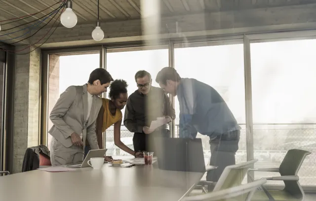 Fotografia de un equipo de trabajo hablando sobre una mesa