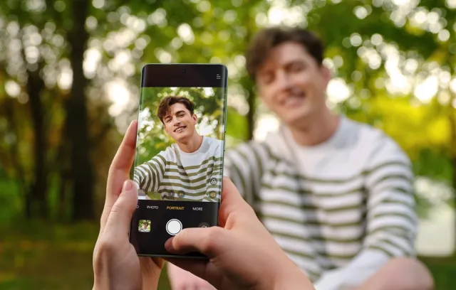 Fotografia de una persona dentro del encuadre del celular con fondo verde
