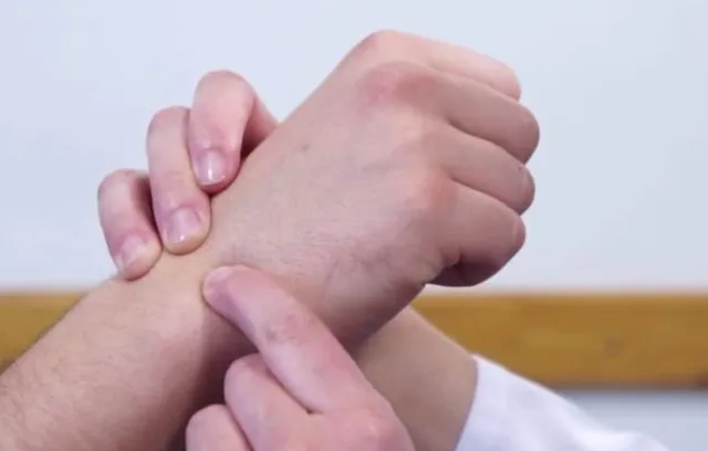 Fotos de una persona señalando la muñeca en la mano de un tercero