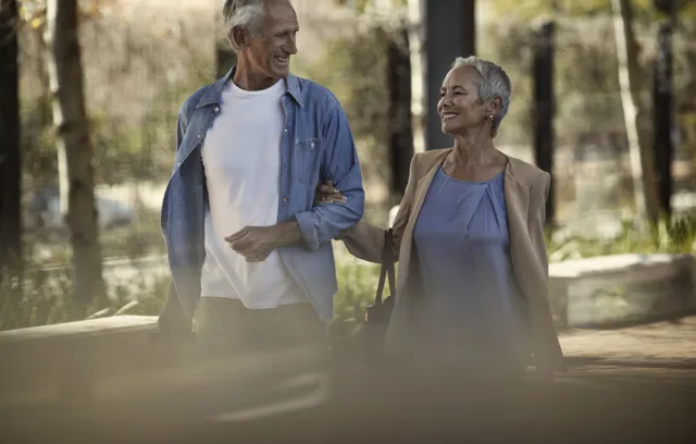 Foto de pareja mayor caminando por el bosque